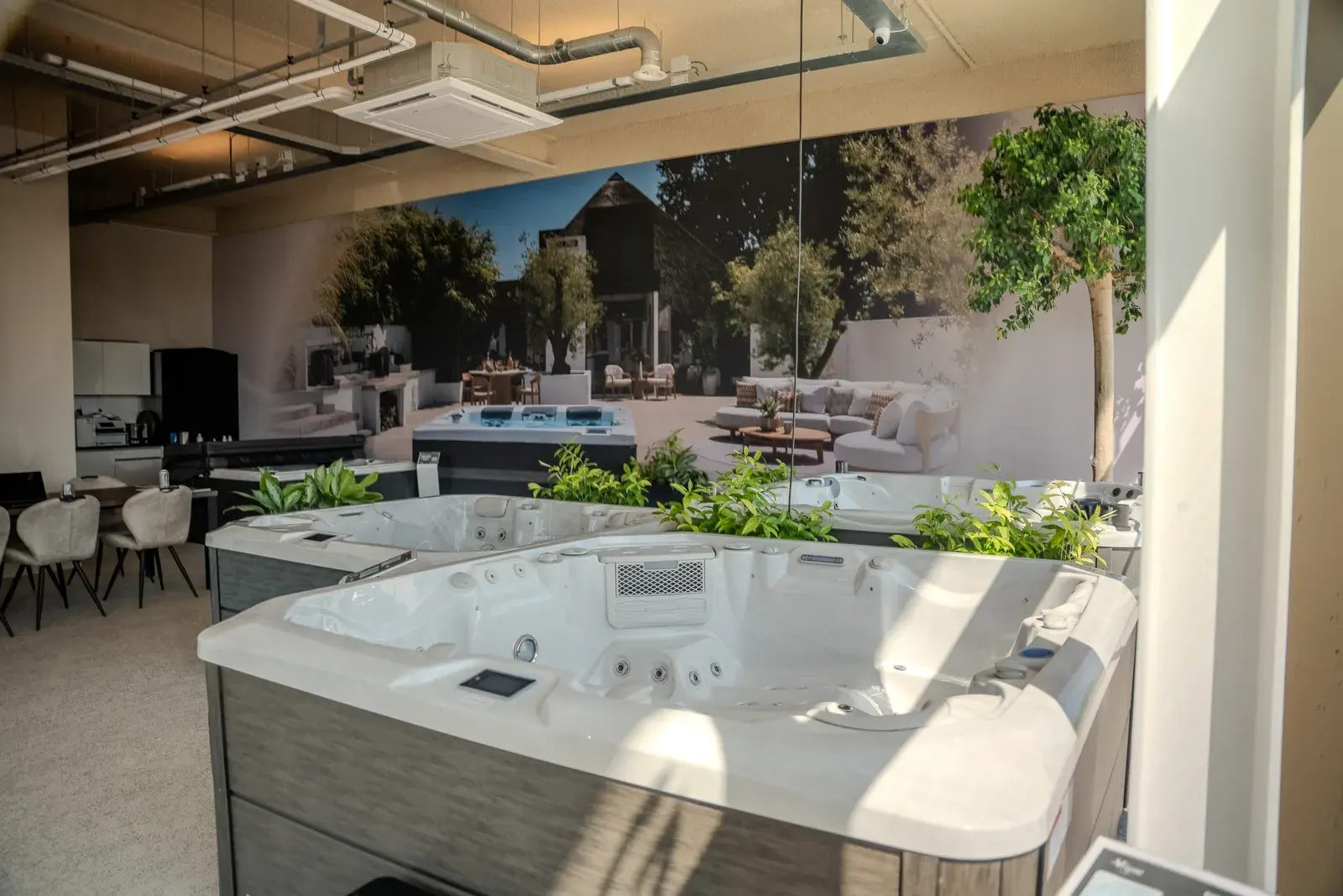 Spas side by side in the showroom, in front of a large wall photo