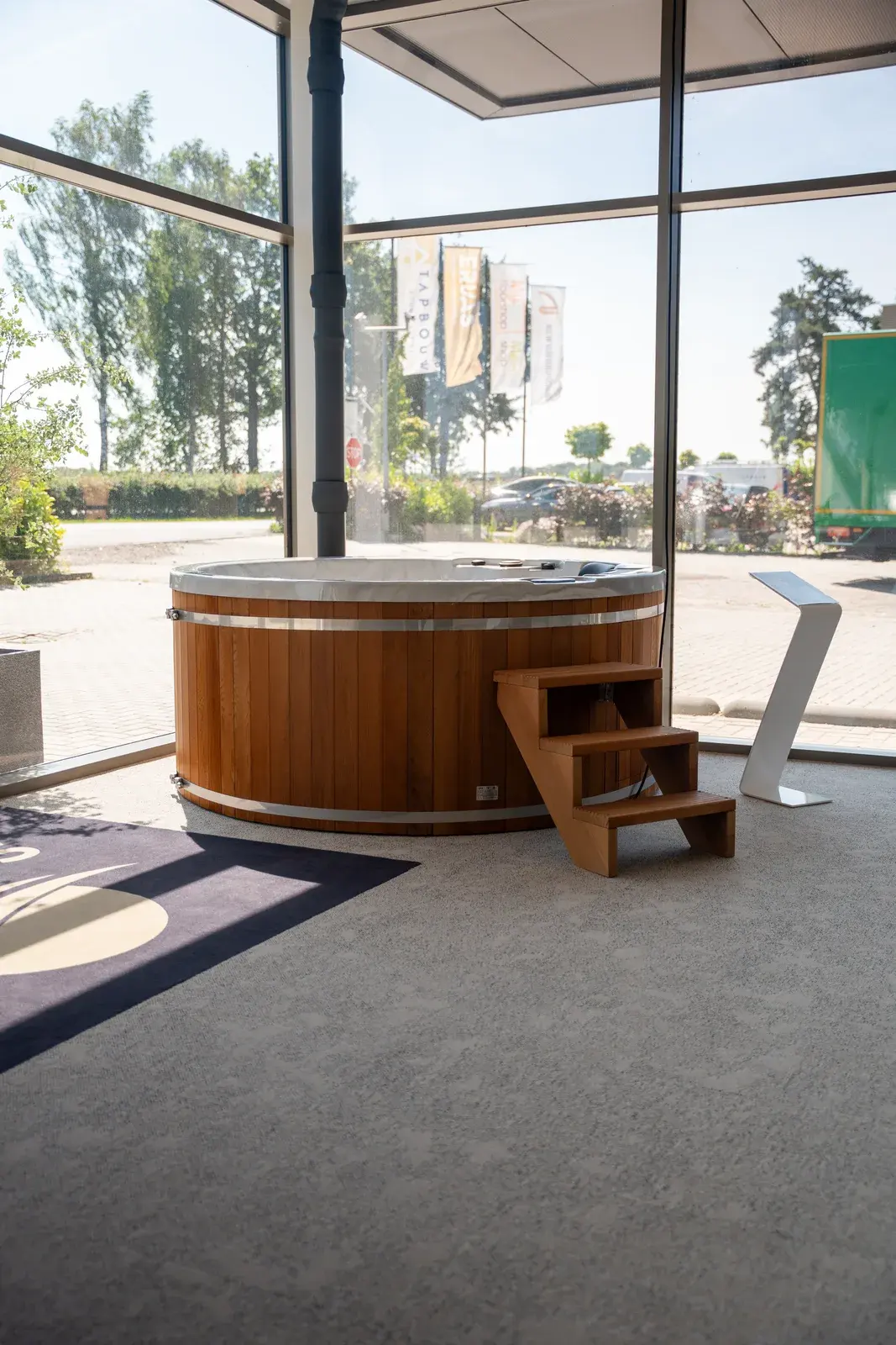 Wooden hot tub with steps by the window in the showroom