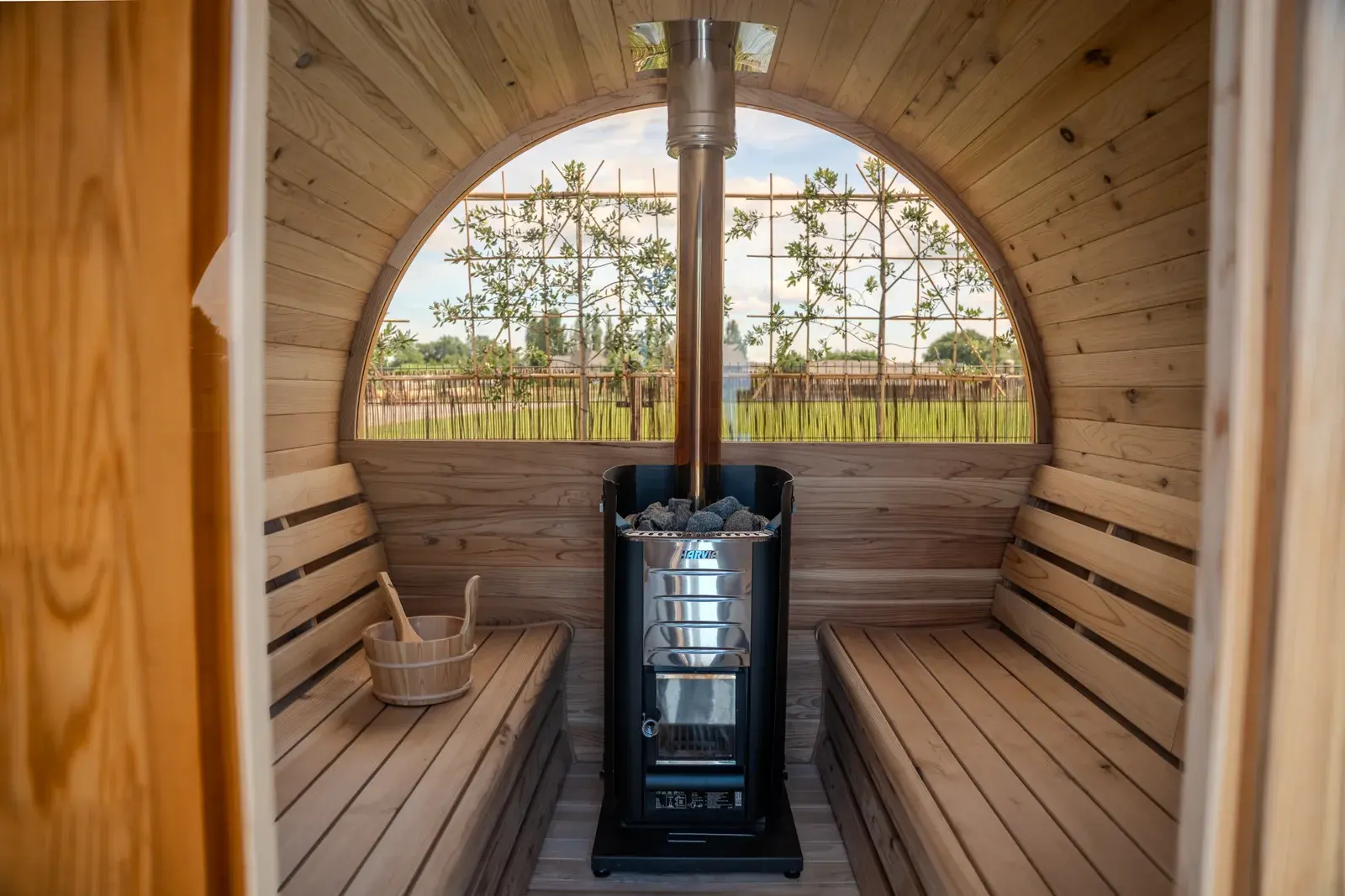 Interior of a barrel sauna with a heater and round window