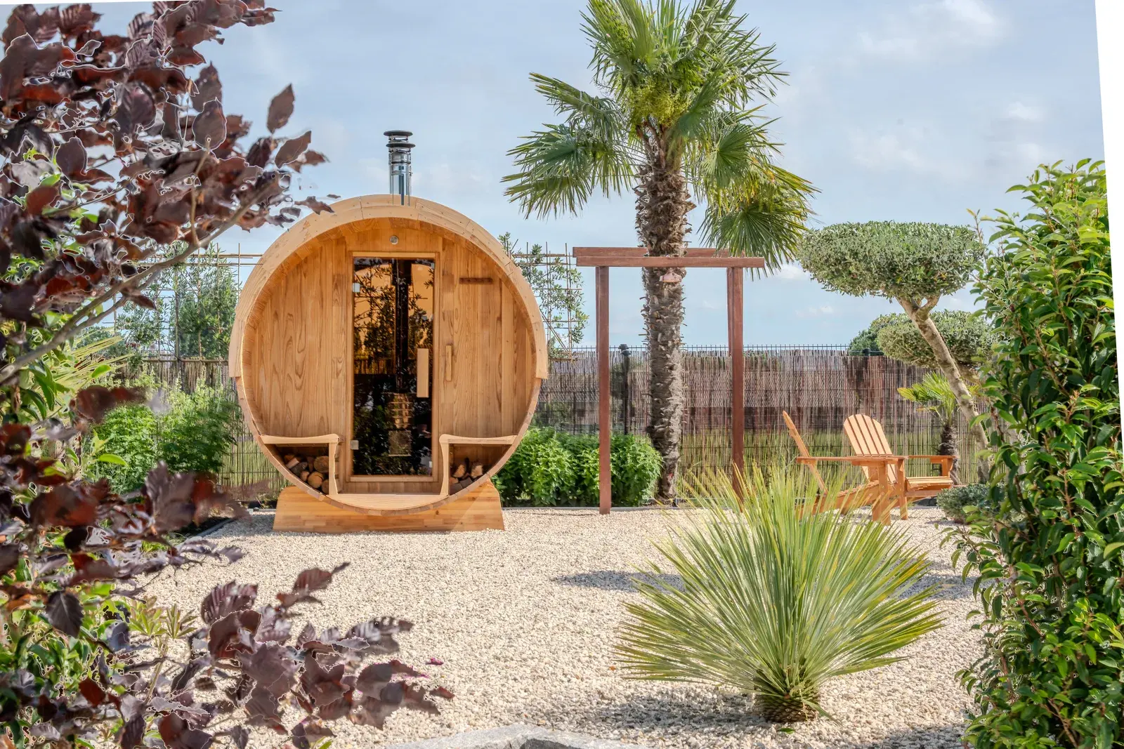 Barrel sauna framed by planting in a landscaped garden